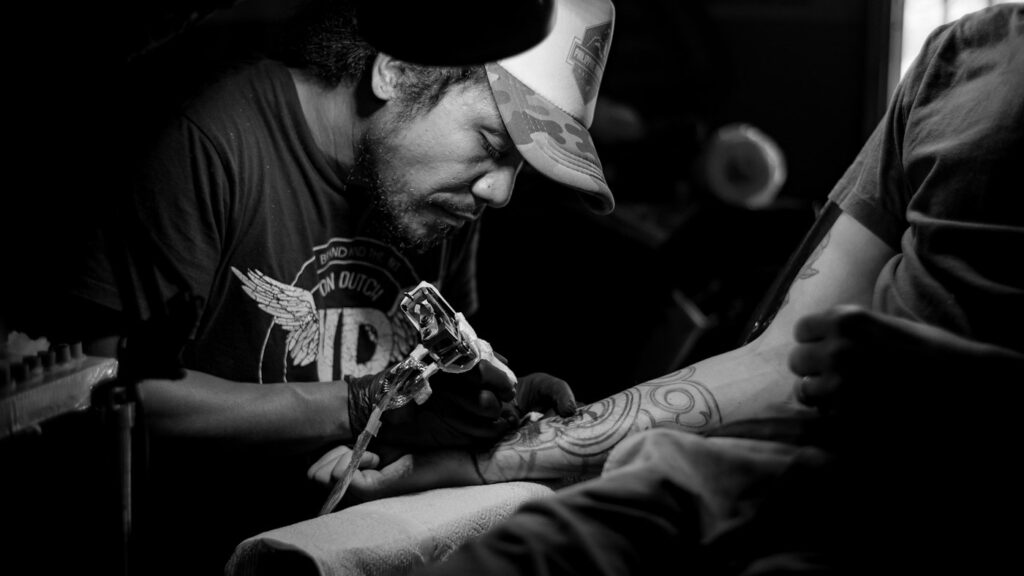 Tattoo artist refining a tattoo in black and white