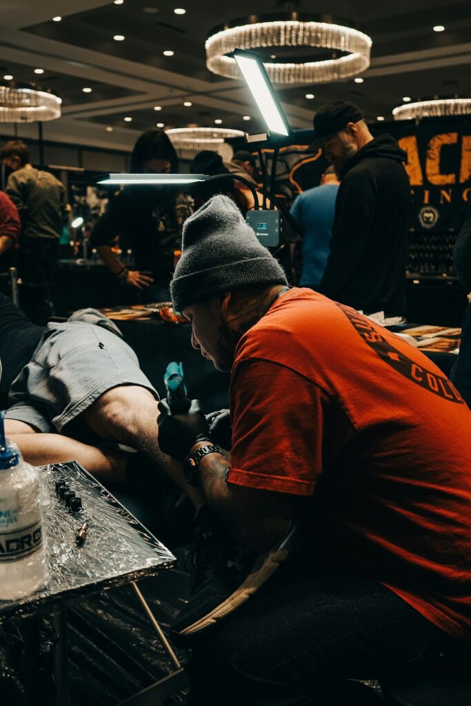 Artists tattooing clients during long sessions at a tattoo convention