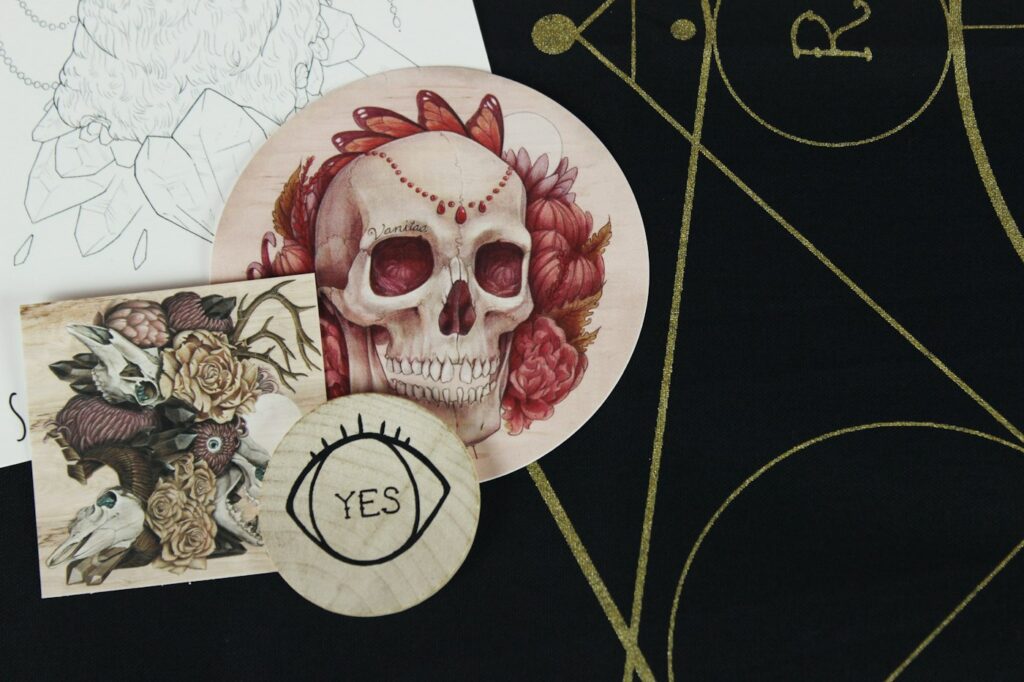 Tattoo flash designs of a skull and roses on a table