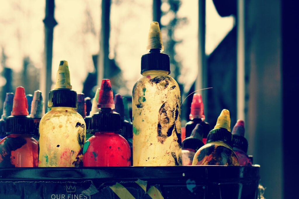Tattoo ink bottles lined up on a shelf in a studio