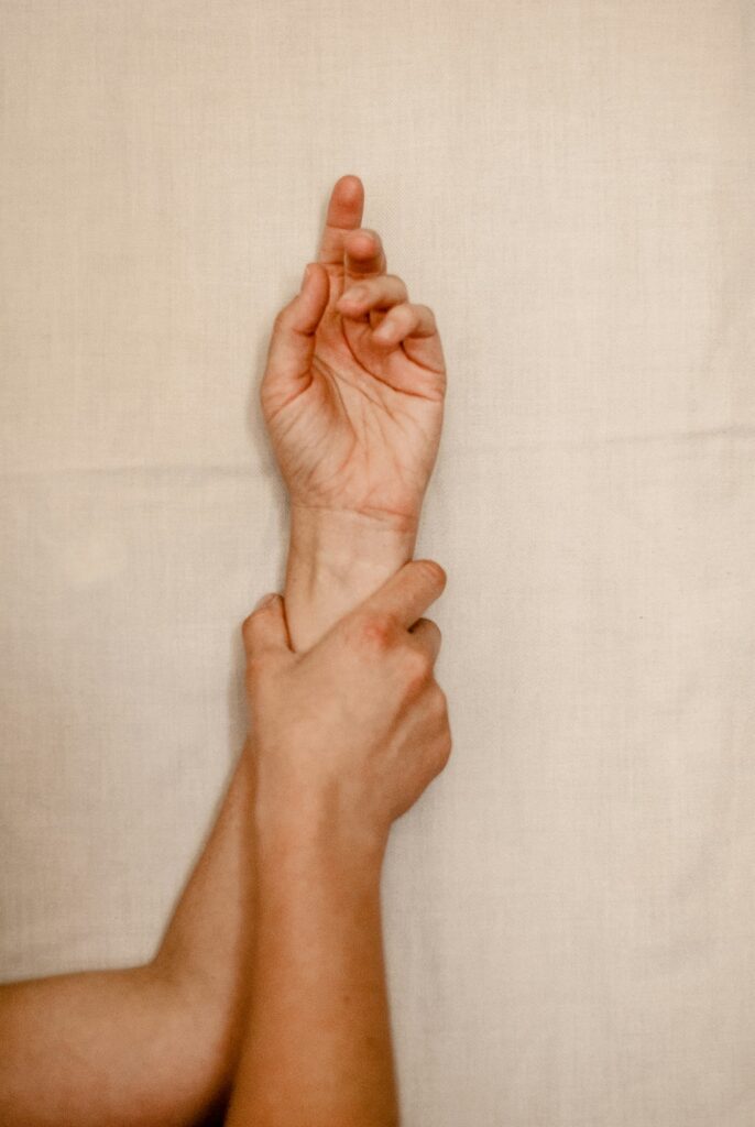Tattoo itching relief: hand holding an itchy wrist instead of scratching