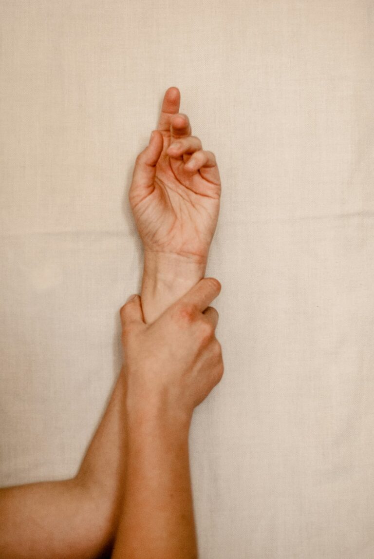 Tattoo itching relief: hand holding an itchy wrist instead of scratching