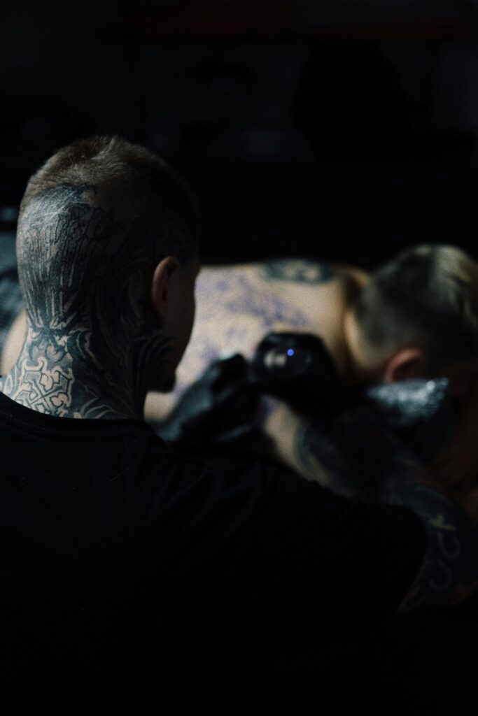 Tattoo session in a dark, moody studio