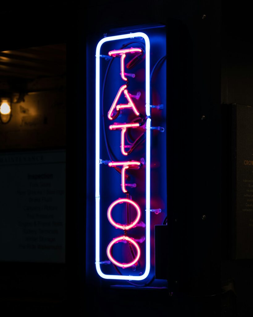 Neon tattoo shop sign at night