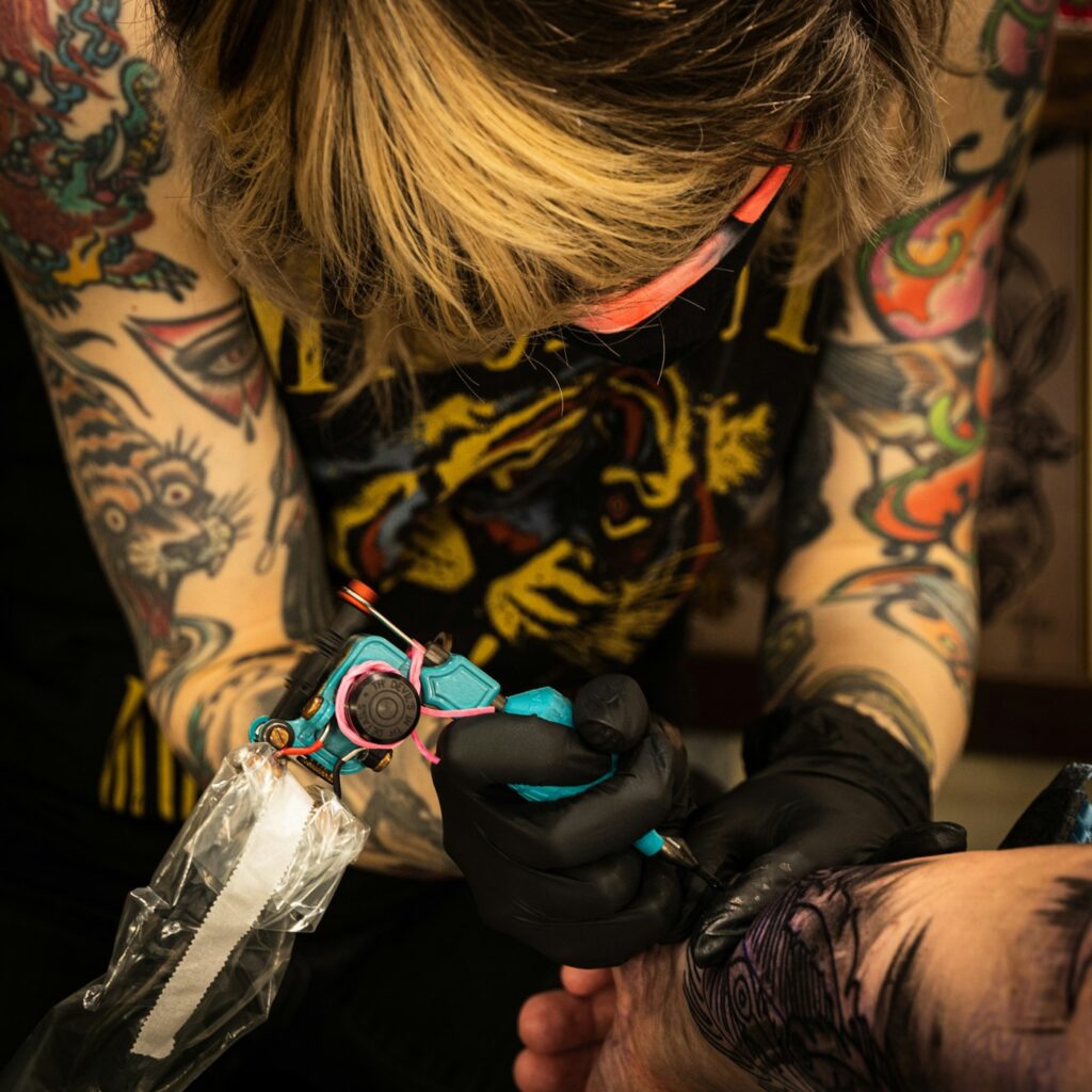 Tattoo styles: tattoo artist with colorful neo traditional sleeves at work