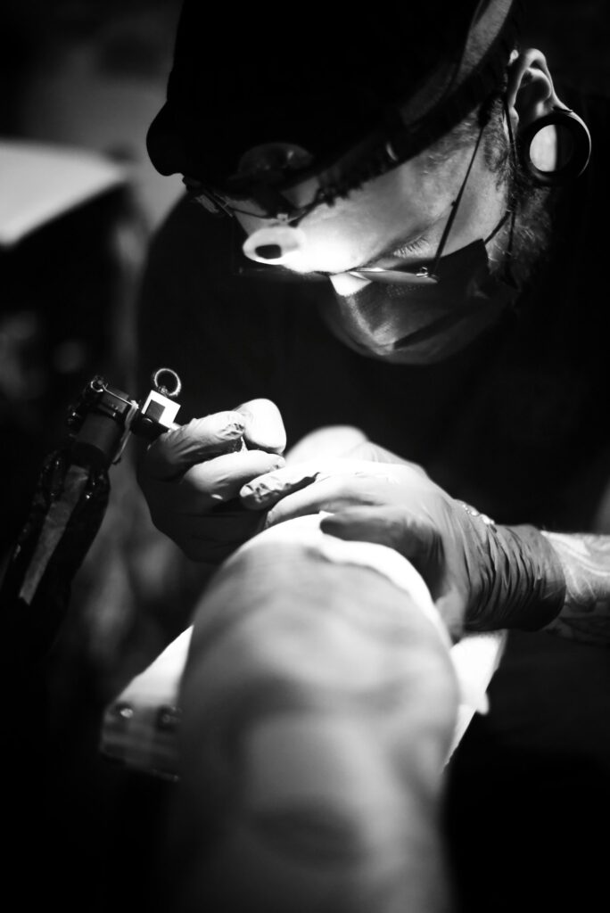 Tattoo touch up: tattoo artist working under a bright lamp