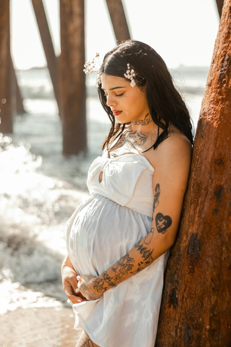 Tattoo while pregnant: expecting mother with an arm tattoo sleeve in a white dress