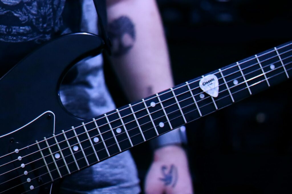Guitarist with healed forearm tattoos