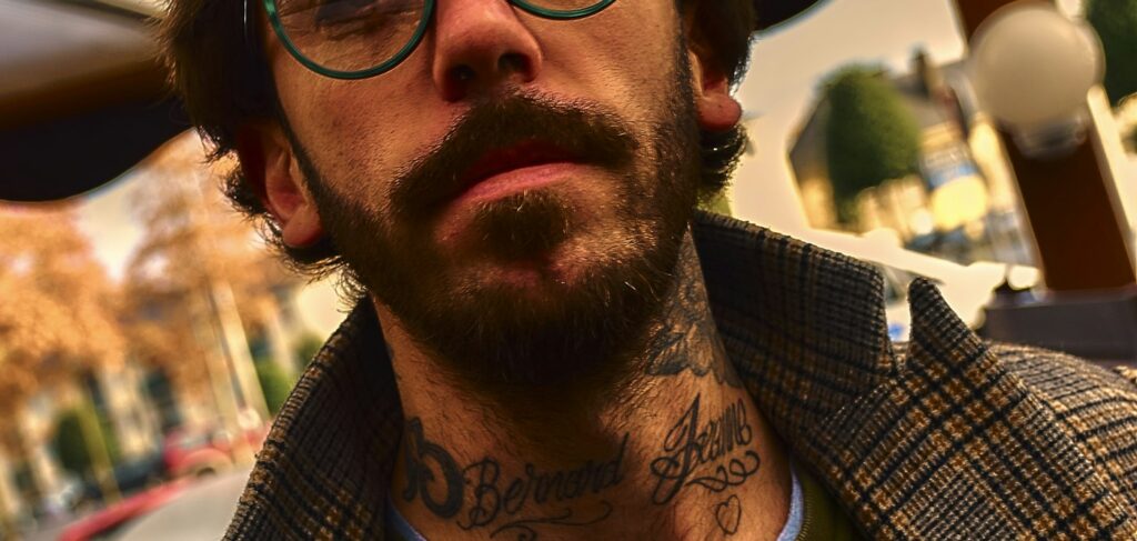 Script lettering tattoo on a man's throat