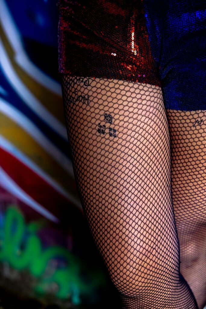 Thigh tattoos for women: tiny symbol under fishnet tights