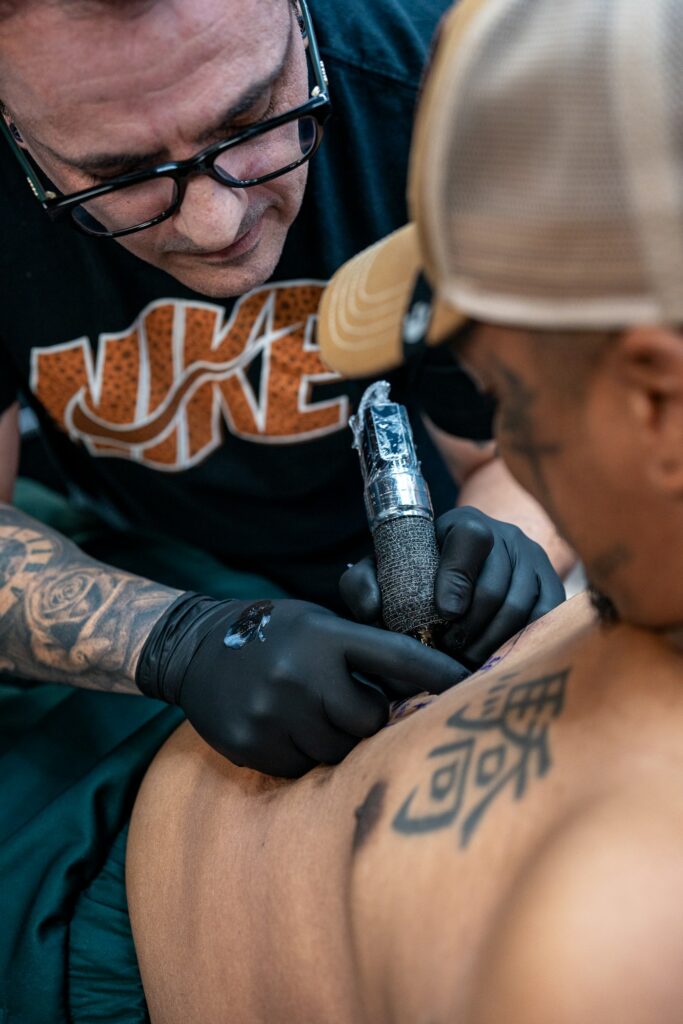 Tribal back tattoo being inked with a machine
