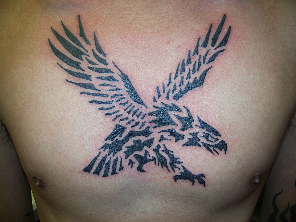 Tribal eagle tattoo with spread wings on the chest