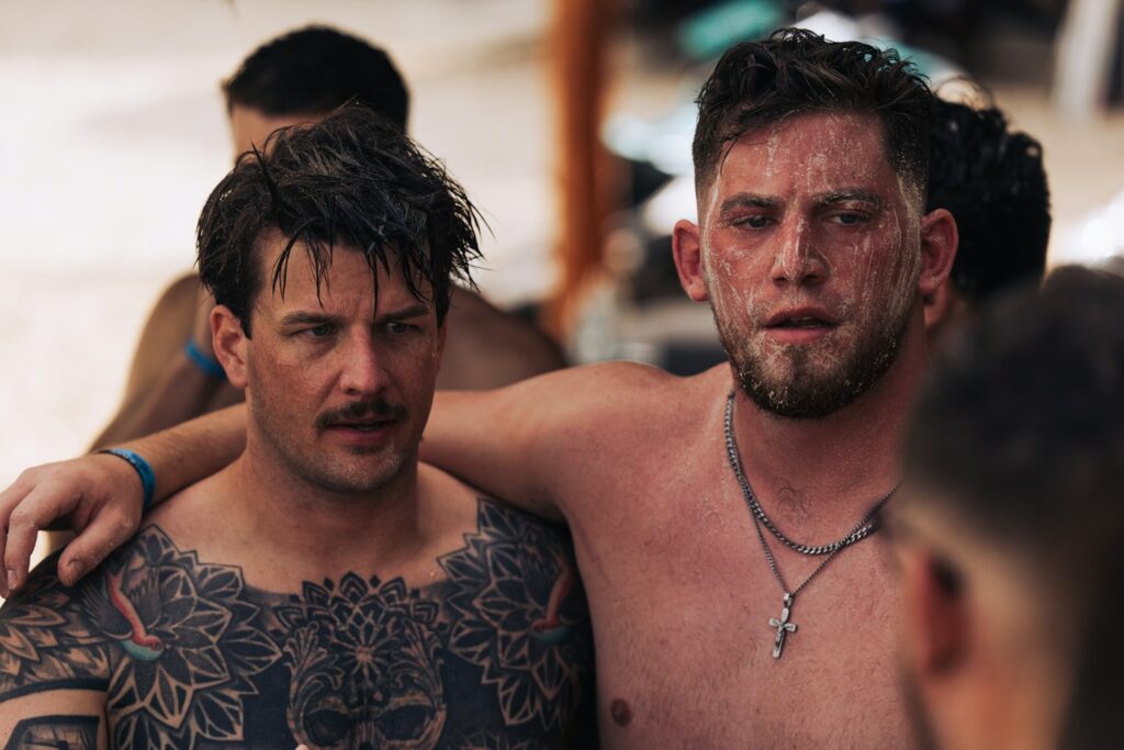Two friends showing their chest tattoos
