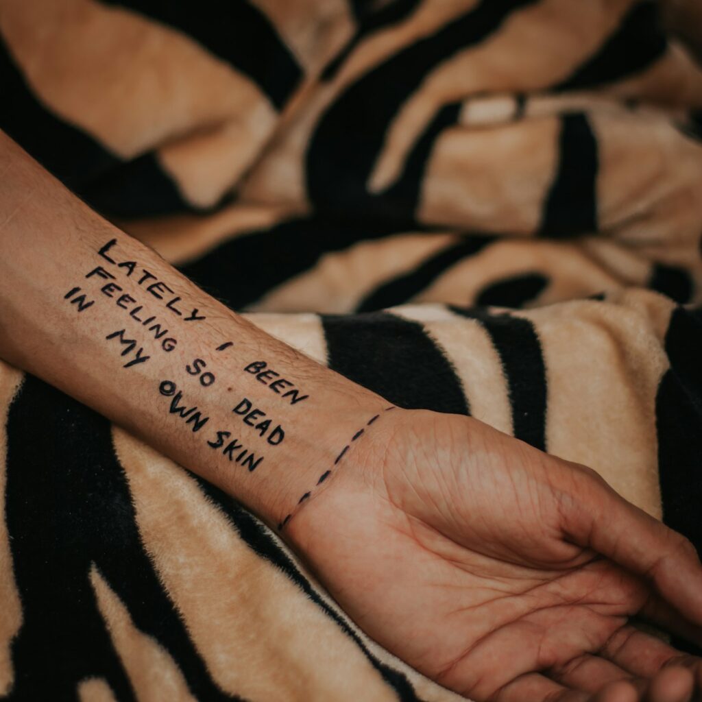 Typewriter style verse tattoo on the inner wrist
