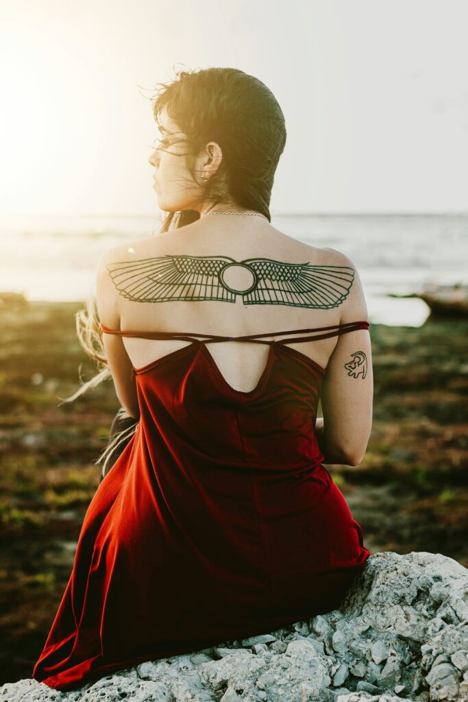 Winged scarab tattoo across a woman's shoulders