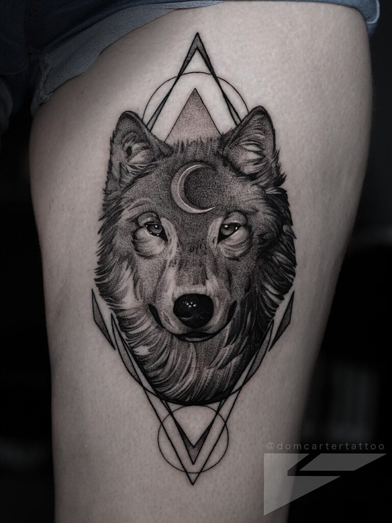 Wolf head with crescent moon and geometric triangles tattoo