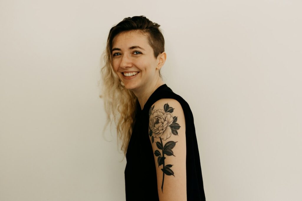 Smiling woman with tattoos on her arm