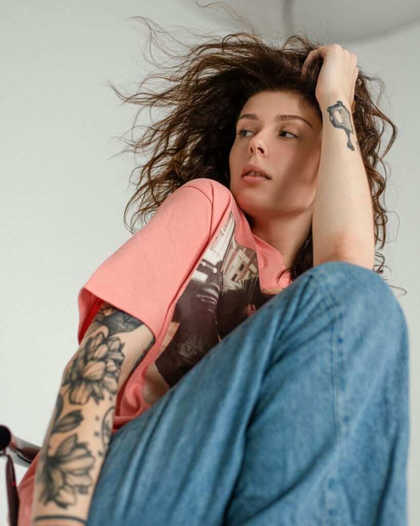 Tattooed woman sitting on a chair with a half sleeve