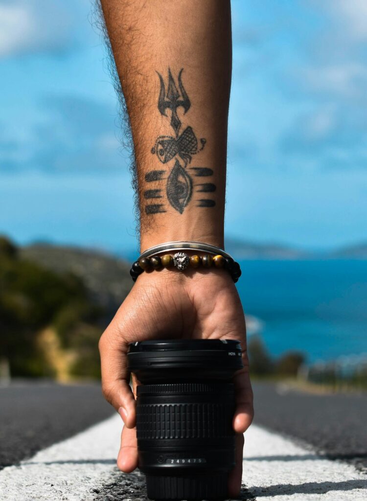 Wrist tattoo above a beaded bracelet