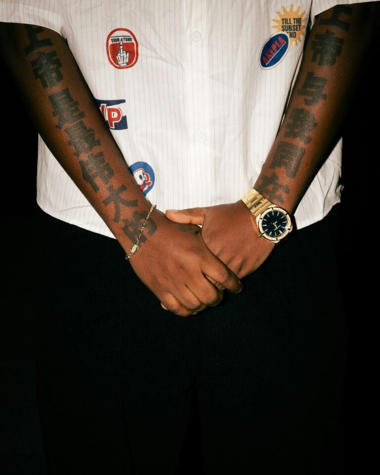 Wrist tattoos for men: tattooed arms and hands with a gold watch