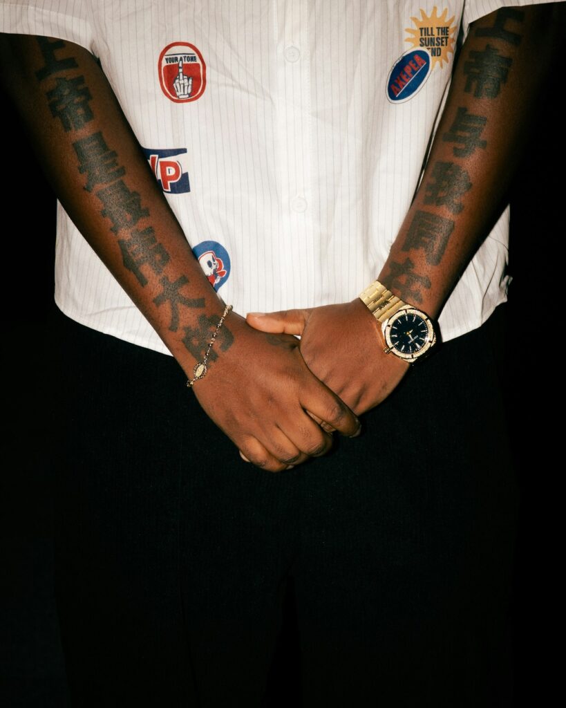 Wrist tattoos for men: tattooed arms and hands with a gold watch