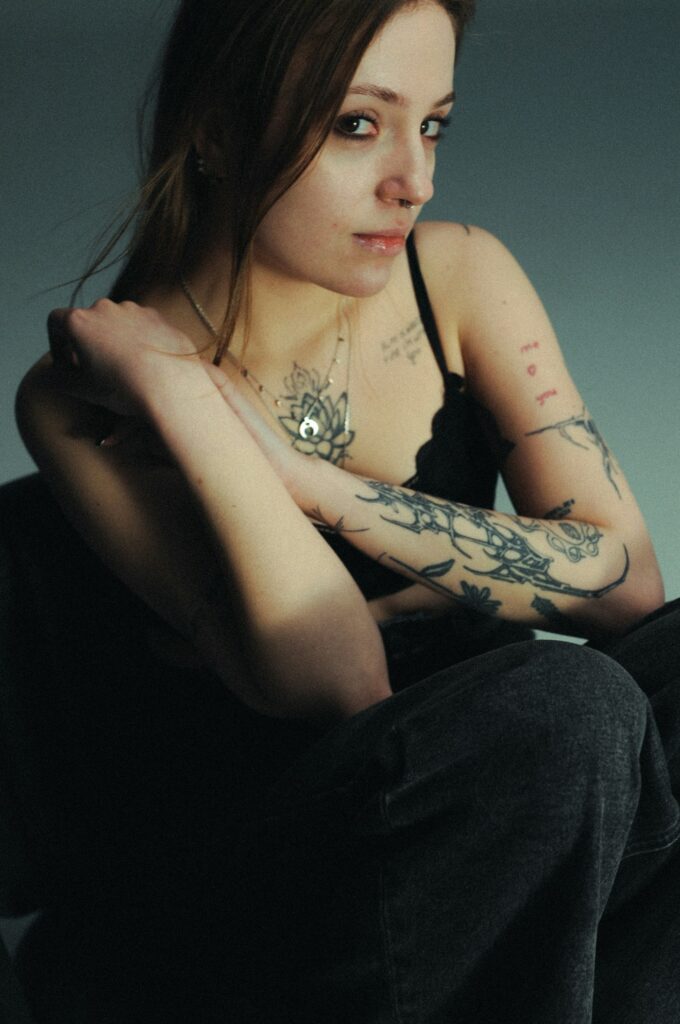 Young woman with tattoos on her arms and chest