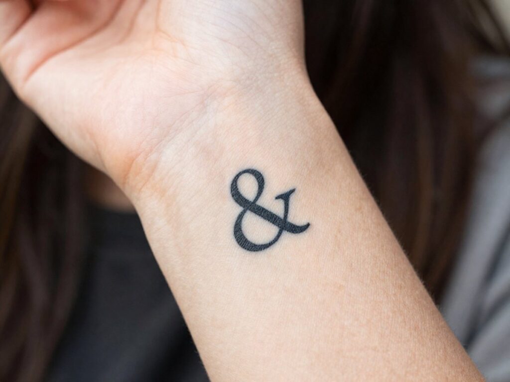 Ampersand tattoo meaning: small ampersand tattoo on the inner wrist
