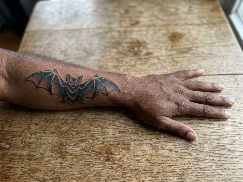 Bat tattoo: traditional bat on the outer forearm