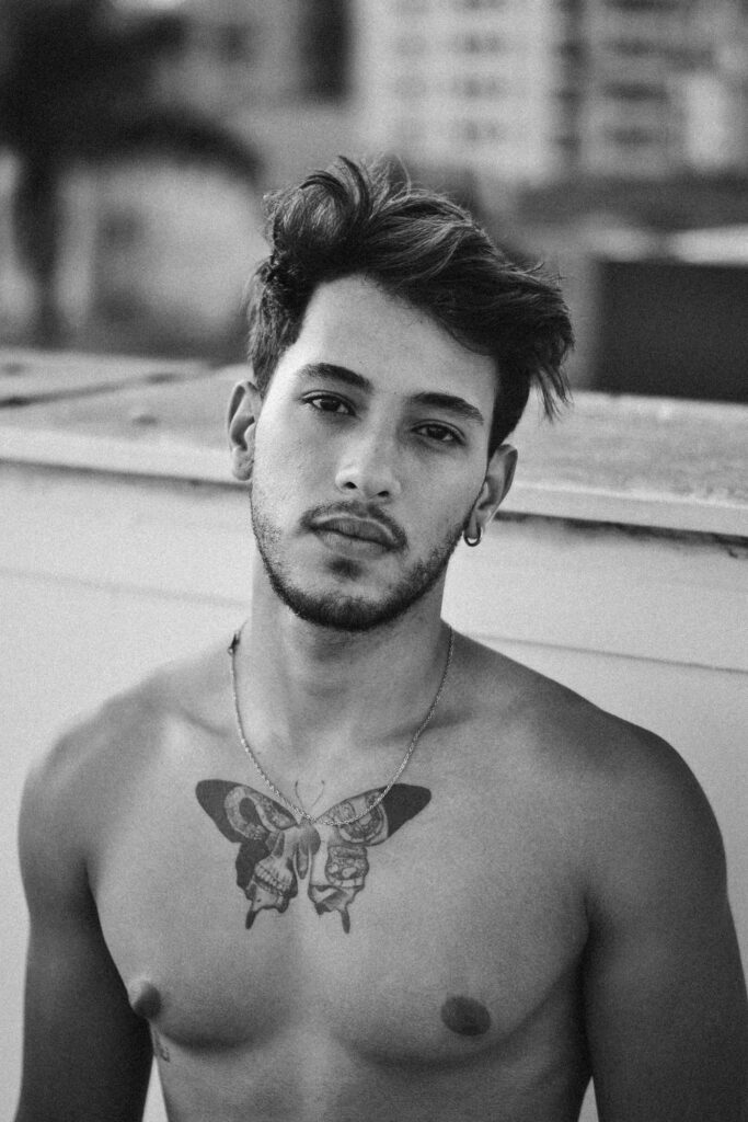 Man with a black butterfly tattoo in the center of his chest