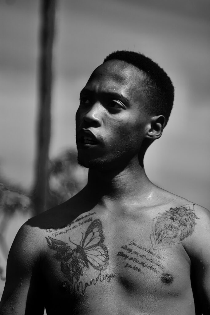Man with a large butterfly tattoo on his chest in black and white