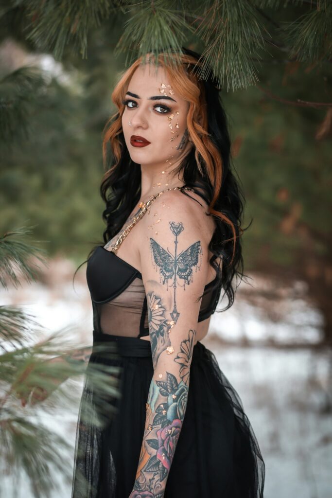 Woman with a butterfly tattoo on her shoulder and arm sleeve