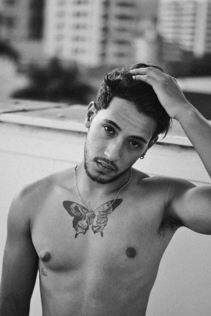 Butterfly tattoos for men: black and white portrait of a man with a butterfly tattoo on his chest
