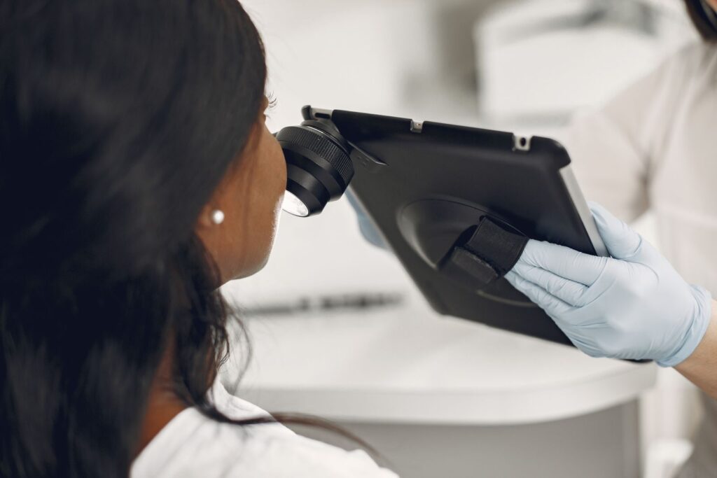 Dermatologist examining skin with a digital dermatoscope