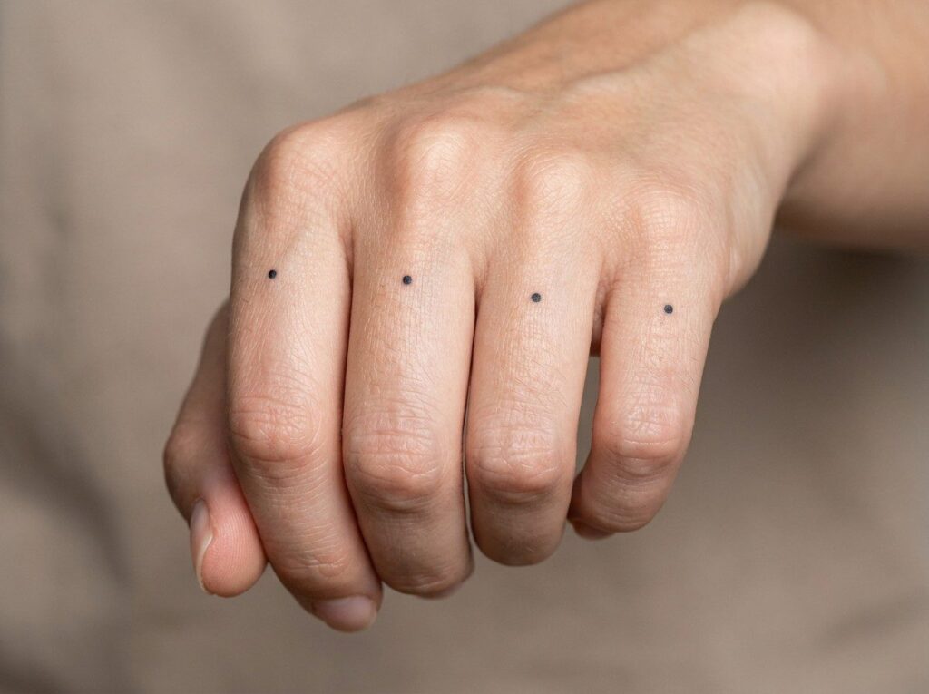 Finger tattoos for women: knuckle dots on the knuckles of the fingers