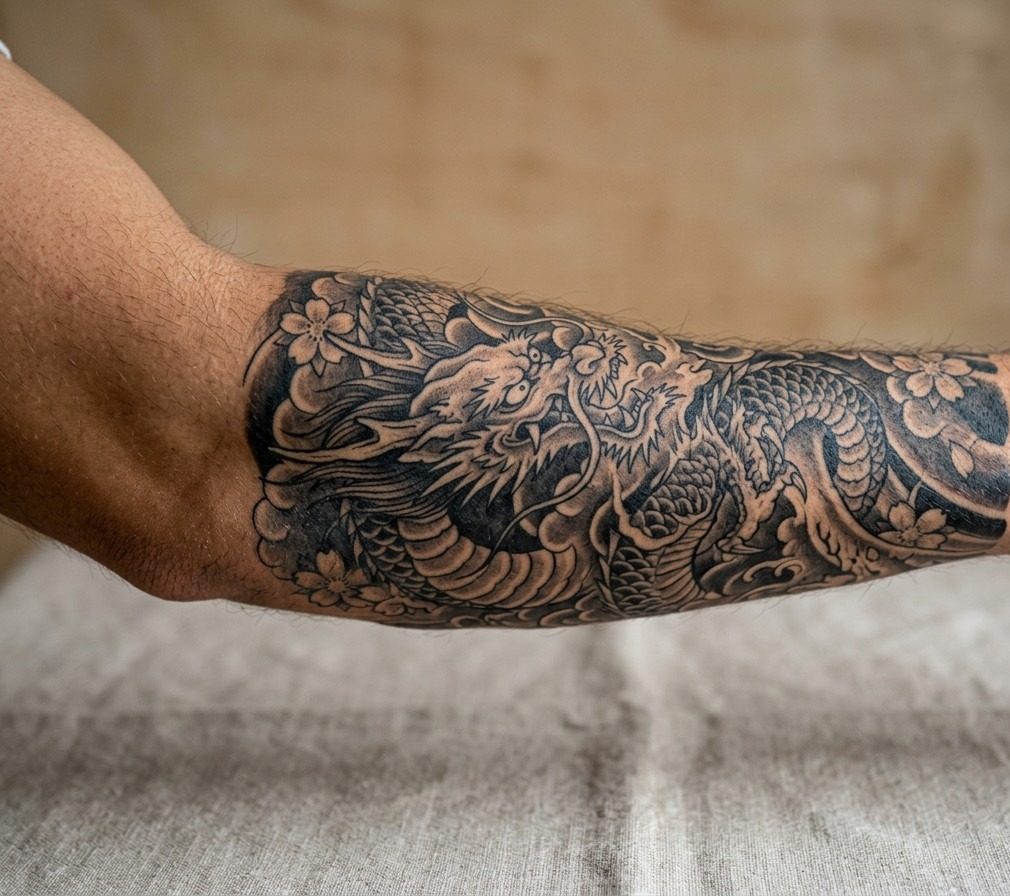 Japanese dragon tattoo: black and grey japanese dragon on the outer forearm