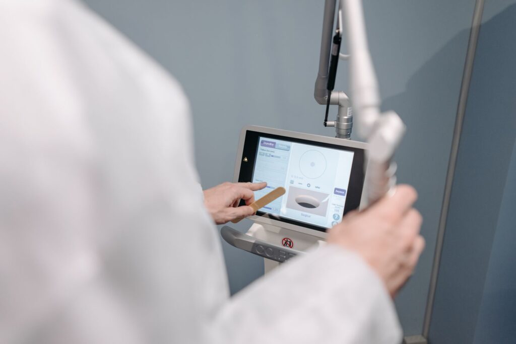 Laser technician adjusting the settings on a medical laser touch screen