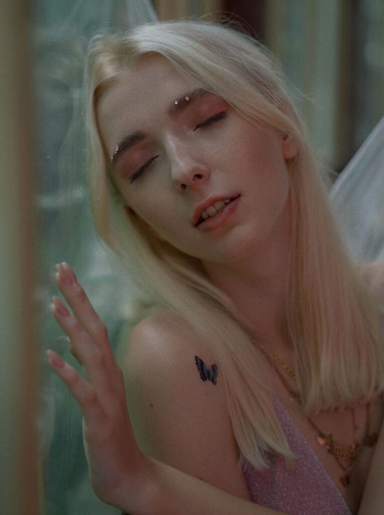 Tiny black butterfly tattoo on the shoulder